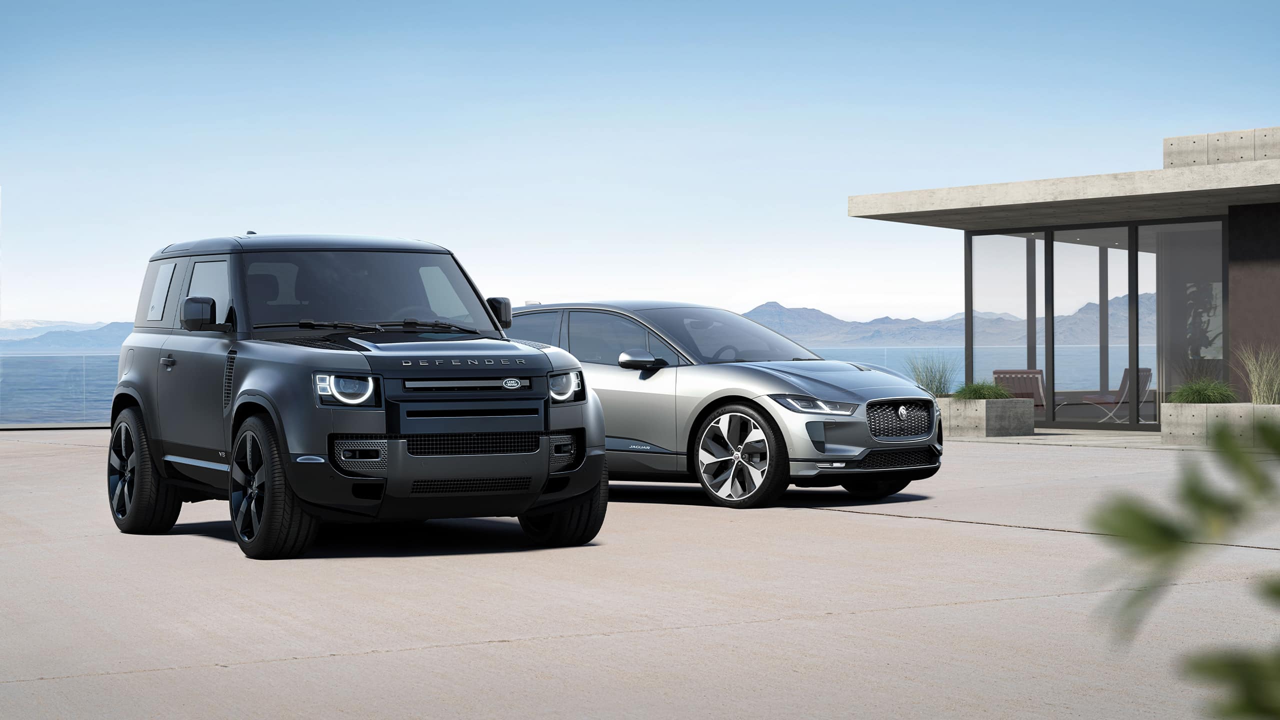 Defender And Jaguar Parked outside